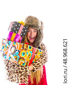 Blond winter kid girl with stacked presents smiling happy with fur hat. Стоковое фото, агентство Ingram Publishing / Фотобанк Лори