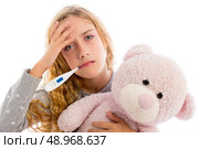blond girl with thermometer and flu cold in pyjama  grumpy face with teddy bear. Стоковое фото, агентство Ingram Publishing / Фотобанк Лори