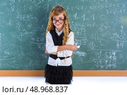 Clever nerd pupil blond girl in green board student schoolgirl. Стоковое фото, агентство Ingram Publishing / Фотобанк Лори