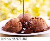 chocolate pouring into scoops of  ice cream in a plate. Стоковое фото, агентство Ingram Publishing / Фотобанк Лори