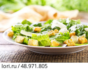 plate of caesar salad on wooden table. Стоковое фото, агентство Ingram Publishing / Фотобанк Лори