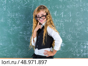 Clever nerd pupil blond girl in green board thinking student schoolgirl. Стоковое фото, агентство Ingram Publishing / Фотобанк Лори