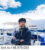 Sailor man in marina port with boats background and blue cap. Стоковое фото, агентство Ingram Publishing / Фотобанк Лори
