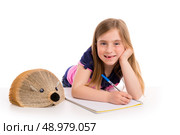 Blond kid girl student with hedgehog book on white background. Стоковое фото, агентство Ingram Publishing / Фотобанк Лори