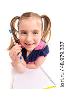 Blond kid indented girl student with spiral notebook in pupil desk. Стоковое фото, агентство Ingram Publishing / Фотобанк Лори