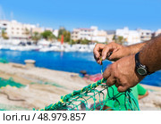 Majorca Cala Ratjada beach Rajada fisherman sewing fishing net. Стоковое фото, агентство Ingram Publishing / Фотобанк Лори