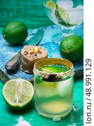 glass alcoholic drink and lime fruits on wooden texture.Selective focus. refreshing cocktail made of rum and lime with ice. Стоковое фото, агентство Ingram Publishing / Фотобанк Лори