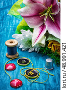 sewing accessories with a bouquet of fresh flowers on turquoise background. Стоковое фото, агентство Ingram Publishing / Фотобанк Лори