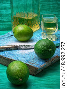 glass alcoholic drink and lime fruits on wooden texture.Selective focus. alcoholic cocktail with additions of lime. Стоковое фото, агентство Ingram Publishing / Фотобанк Лори