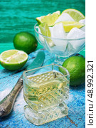 one glass alcoholic drink and lime fruits on wooden texture.Selective focus. alcoholic cocktail with additions of lime. Стоковое фото, агентство Ingram Publishing / Фотобанк Лори