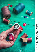 hand dressmaker with wooden buttons .Selective focus. working tool dressmaker. Стоковое фото, агентство Ingram Publishing / Фотобанк Лори
