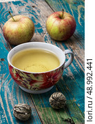 Cup of brewed tea.welding and ripe apple on new background. Cup of apple tea. Стоковое фото, агентство Ingram Publishing / Фотобанк Лори