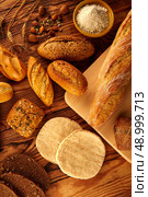 Bread fresh varied mix on golden rustic wood golden table. Стоковое фото, агентство Ingram Publishing / Фотобанк Лори