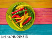 Colorful mexican chili peppers habanero red in wood table background. Стоковое фото, агентство Ingram Publishing / Фотобанк Лори