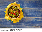 Guacamole with avocado tomatoes mexican food on blue wood. Стоковое фото, агентство Ingram Publishing / Фотобанк Лори