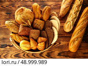 Bread fresh varied mix on golden rustic wood in basket. Стоковое фото, агентство Ingram Publishing / Фотобанк Лори