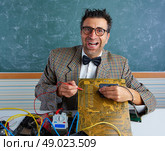 Nerd electronics technician retro teacher silly expression working in pcb. Стоковое фото, агентство Ingram Publishing / Фотобанк Лори