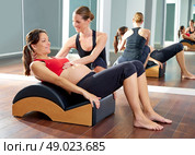 pregnant woman pilates exercise roll back with Wave corrector and personal trainer. Стоковое фото, агентство Ingram Publishing / Фотобанк Лори