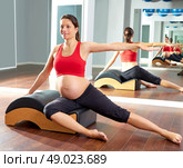 pregnant woman pilates side stretchs exercise with Wave corrector. Стоковое фото, агентство Ingram Publishing / Фотобанк Лори