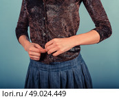 A young woman is buttoning her faux leather shirt. Стоковое фото, агентство Ingram Publishing / Фотобанк Лори