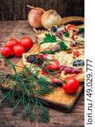 flavorful homemade pizza with bacon. hunk of delicious meat pizza with bacon and olives on the background of the vegetables.The image is tinted. Стоковое фото, агентство Ingram Publishing / Фотобанк Лори