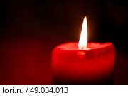 Close-up photo of a flaming red candlelight at christmas time. Стоковое фото, агентство Ingram Publishing / Фотобанк Лори