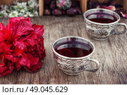 Tea from Sudanese rose. Medicinal tea decoction of hibiscus tea in stylish cups. Стоковое фото, агентство Ingram Publishing / Фотобанк Лори