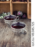 Tea from Sudanese rose. Medicinal tea a decoction of hibiscus tea in stylish cups. Стоковое фото, агентство Ingram Publishing / Фотобанк Лори