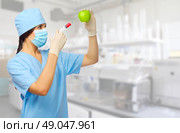Young doctor with syringe and apple at laboratory. Стоковое фото, агентство Ingram Publishing / Фотобанк Лори