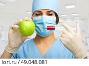 Chemist with syringe and apple at lab. Стоковое фото, агентство Ingram Publishing / Фотобанк Лори