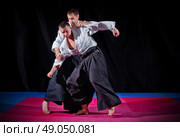 Fight between two aikido fighters on black. Стоковое фото, агентство Ingram Publishing / Фотобанк Лори