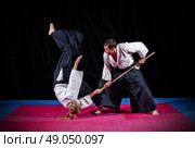 Fight between two aikido fighters on black. Стоковое фото, агентство Ingram Publishing / Фотобанк Лори