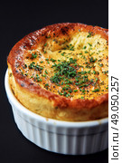Delicious Cheese Souffl Baked to Perfection With Fresh Herbs in a Ramekin. Стоковое AI-изображение, AI-художник Юлия Гапеенко / Фотобанк Лори