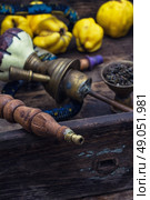 Hookah and quince.. Disassembled the hookah in wooden box with fresh fruit quince in a vintage style. Стоковое фото, агентство Ingram Publishing / Фотобанк Лори