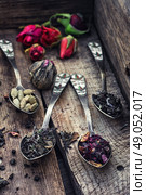 by spilling tea spoons. dry tea infuser scattered on wooden table. Стоковое фото, агентство Ingram Publishing / Фотобанк Лори