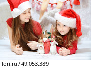 Two cute girls enjoying the christmas. Стоковое фото, агентство Ingram Publishing / Фотобанк Лори