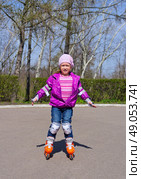 Little girl skating on roller skates at park. Стоковое фото, агентство Ingram Publishing / Фотобанк Лори