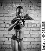 Muscular woman on grey brick wall (monochrome version) Стоковое фото, агентство Ingram Publishing / Фотобанк Лори