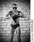 Muscular sporty woman on grey brick wall (monochrome version) Стоковое фото, агентство Ingram Publishing / Фотобанк Лори