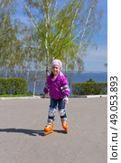 Little girl rides roller skates at park. Стоковое фото, агентство Ingram Publishing / Фотобанк Лори