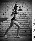 Muscular sporty woman on grey brick wall (monochrome version) Стоковое фото, агентство Ingram Publishing / Фотобанк Лори
