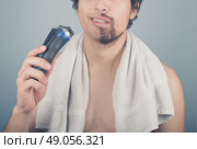 A young man cannot finish shaving because his electric razor is broken. Стоковое фото, агентство Ingram Publishing / Фотобанк Лори