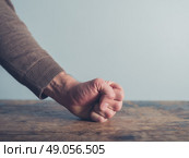 Closeup on a man slamming his fist on a wooden table. Стоковое фото, агентство Ingram Publishing / Фотобанк Лори