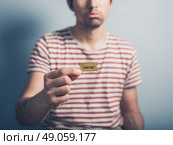 A sad and lonely man is holding a cinema ticket. Стоковое фото, агентство Ingram Publishing / Фотобанк Лори