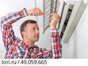 Man repairing his air conditioning system. Стоковое фото, агентство Ingram Publishing / Фотобанк Лори