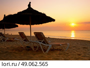 sunrise over the parasol on the beach in Tunisia. Стоковое фото, агентство Ingram Publishing / Фотобанк Лори