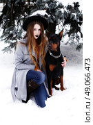 Young woman in winter park with dog having fun. Стоковое фото, агентство Ingram Publishing / Фотобанк Лори