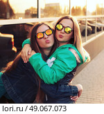 Close up fashion portrait of two young hipster girl friends, wearing mirrored sunglasses, having blonde and ombre hairs. Стоковое фото, агентство Ingram Publishing / Фотобанк Лори