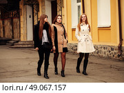 Three fashionable girlfriends walking in the city. Стоковое фото, агентство Ingram Publishing / Фотобанк Лори