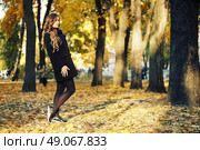 young blonde woman in autumn in park smiling wearing black coat and blue scarf. Стоковое фото, агентство Ingram Publishing / Фотобанк Лори